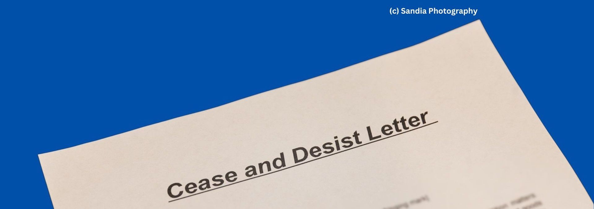 Close-up of a cease and desist letter with a blue background.